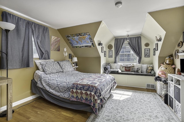 bedroom featuring hardwood / wood-style flooring and vaulted ceiling