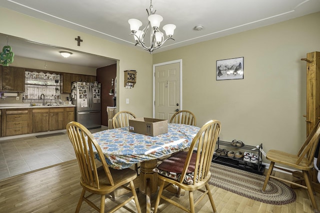 dining room featuring an inviting chandelier, light hardwood / wood-style floors, and sink