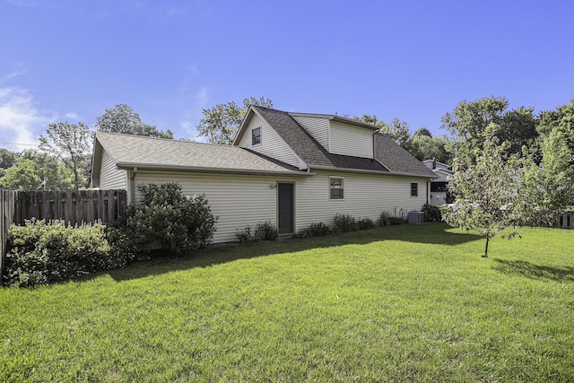 view of side of home with cooling unit and a yard