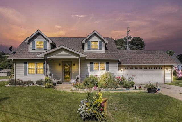 cape cod home featuring a garage and a yard