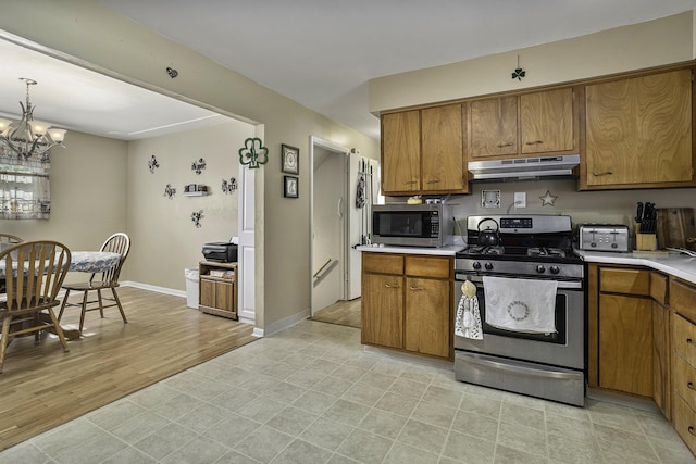 kitchen with an inviting chandelier and appliances with stainless steel finishes