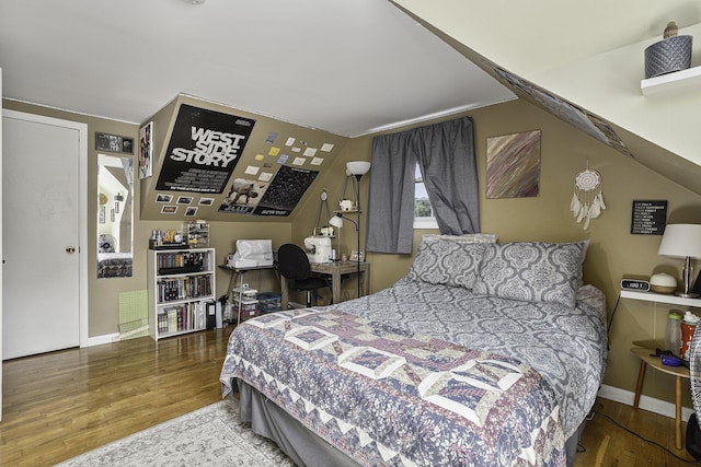 bedroom featuring lofted ceiling and hardwood / wood-style floors