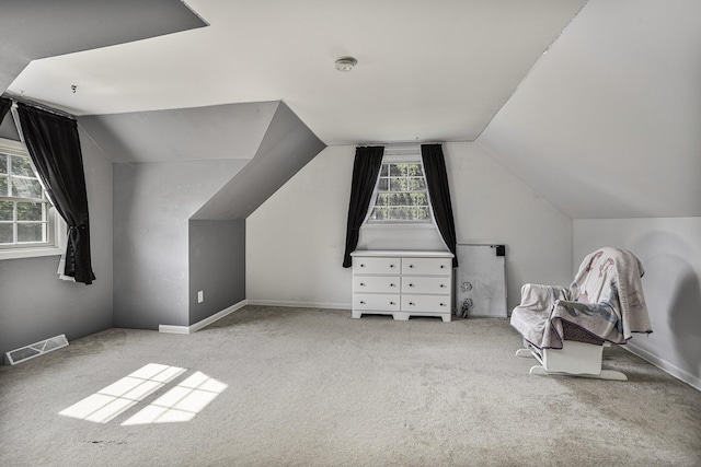 additional living space with lofted ceiling and light carpet