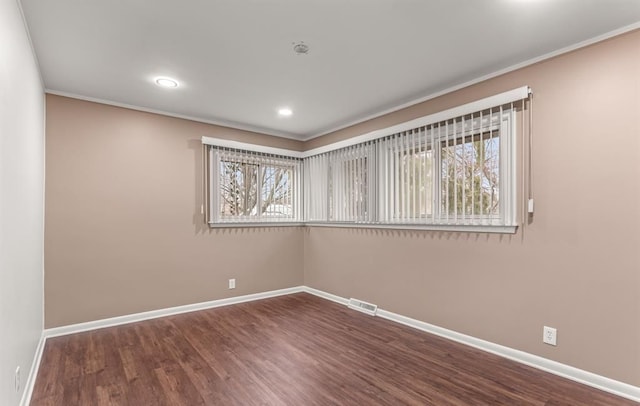 spare room with ornamental molding, plenty of natural light, and wood-type flooring