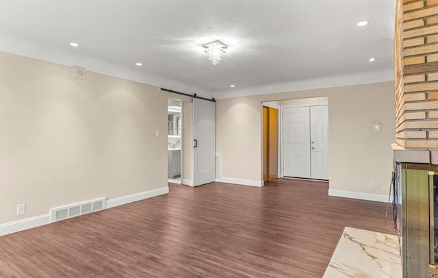 interior space with dark wood-type flooring and a barn door