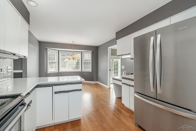 kitchen featuring light countertops, appliances with stainless steel finishes, light wood-type flooring, and white cabinetry