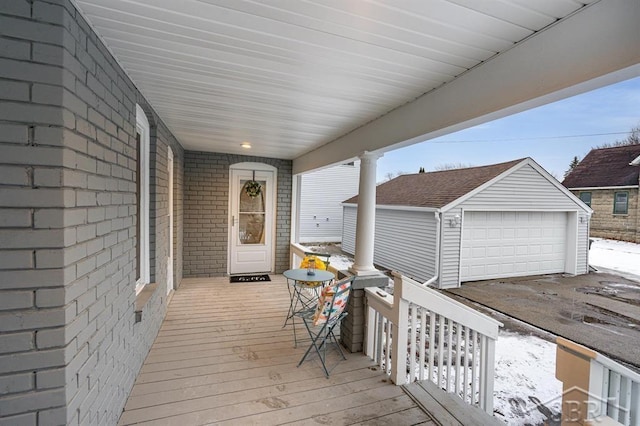 wooden deck featuring a garage, an outdoor structure, and a porch