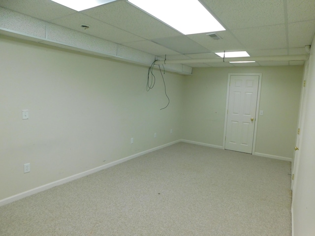 basement featuring carpet floors and a paneled ceiling