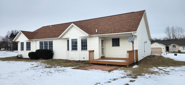 snow covered house featuring a garage