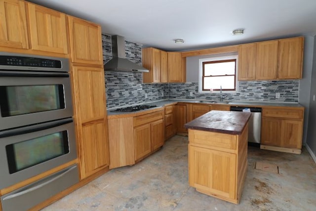 kitchen with decorative backsplash, wall chimney exhaust hood, a kitchen island, stainless steel appliances, and a sink