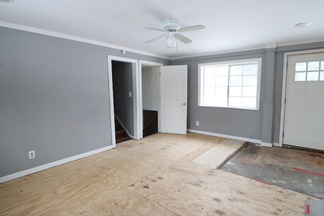 foyer with baseboards, stairs, ornamental molding, and a ceiling fan