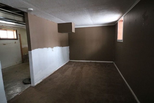 basement featuring a textured ceiling and baseboards