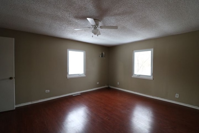 unfurnished room featuring dark wood-type flooring, plenty of natural light, baseboards, and ceiling fan