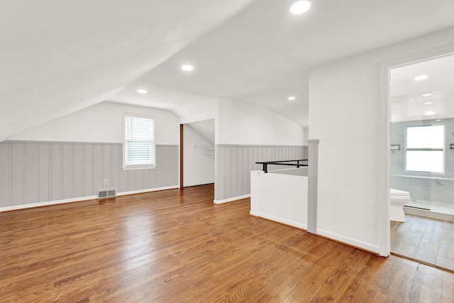 bonus room with lofted ceiling and hardwood / wood-style floors