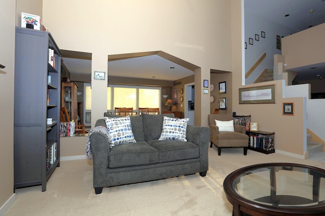 living room with light carpet and a towering ceiling