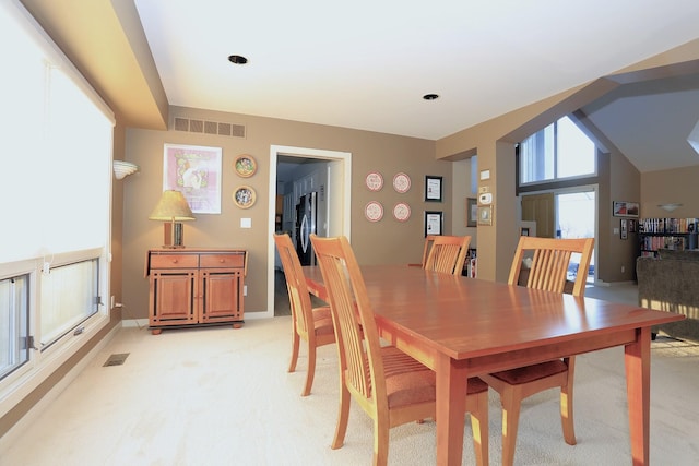 dining space with light carpet and lofted ceiling