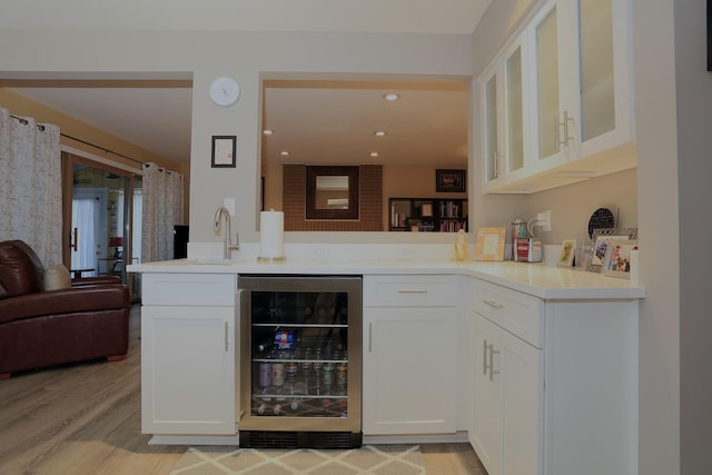 bar featuring white cabinets, sink, wine cooler, and light hardwood / wood-style flooring