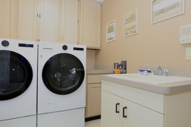 washroom with cabinets, separate washer and dryer, and sink