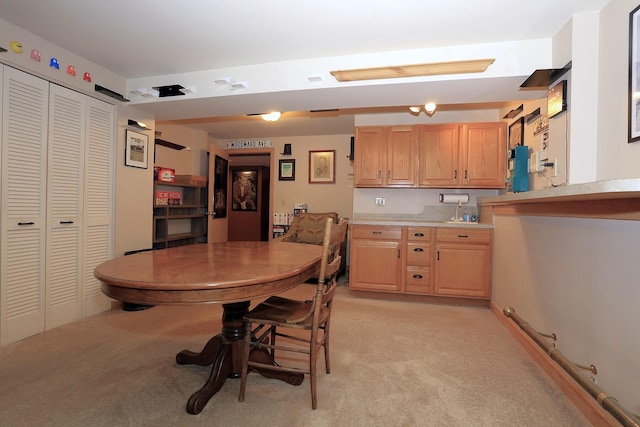 kitchen featuring light colored carpet and light brown cabinetry