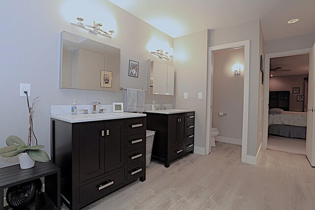 bathroom with hardwood / wood-style flooring, vanity, and toilet