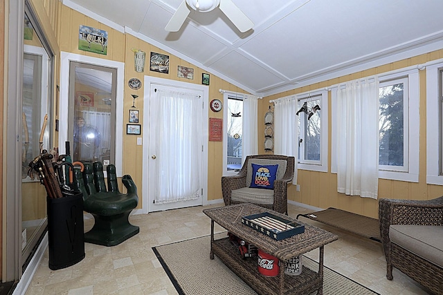 sitting room with vaulted ceiling, ceiling fan, and wood walls