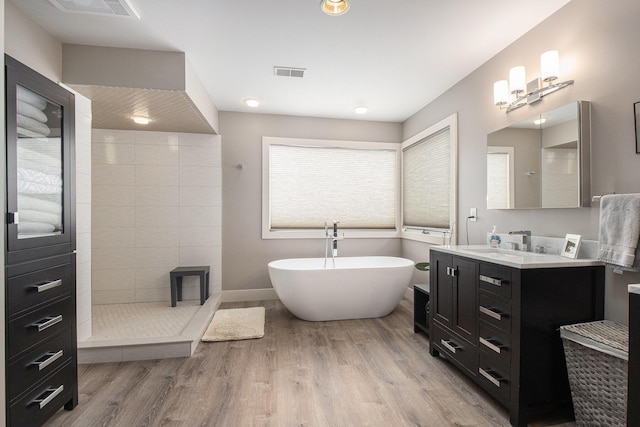 bathroom featuring vanity, wood-type flooring, and separate shower and tub