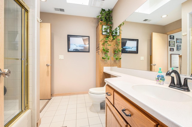 full bathroom with toilet, combined bath / shower with glass door, a skylight, vanity, and tile patterned flooring