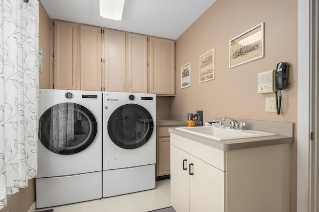 washroom with cabinets, sink, washing machine and dryer, and light tile patterned floors