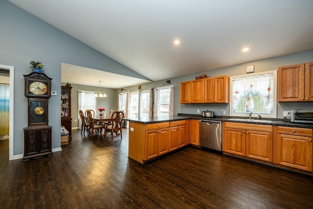 kitchen with sink, vaulted ceiling, stainless steel dishwasher, kitchen peninsula, and pendant lighting