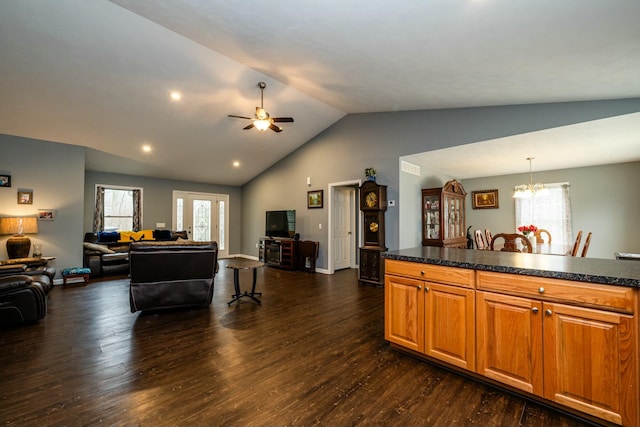 kitchen featuring pendant lighting, lofted ceiling, ceiling fan with notable chandelier, and dark wood-type flooring