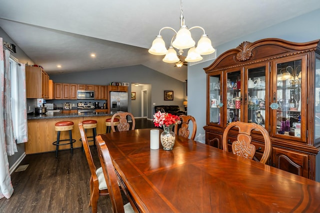 dining room with dark hardwood / wood-style flooring, vaulted ceiling, and an inviting chandelier