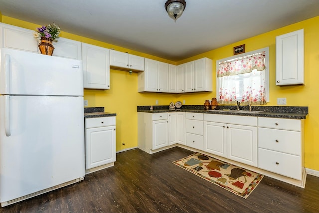 kitchen featuring white fridge, sink, dark wood-type flooring, and white cabinets