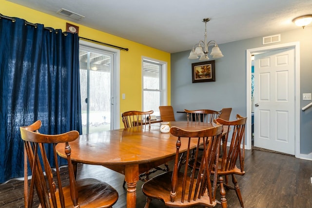 dining space featuring dark hardwood / wood-style floors and a chandelier