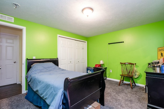 bedroom featuring carpet flooring, a textured ceiling, and a closet