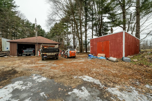 view of yard featuring a garage and an outbuilding