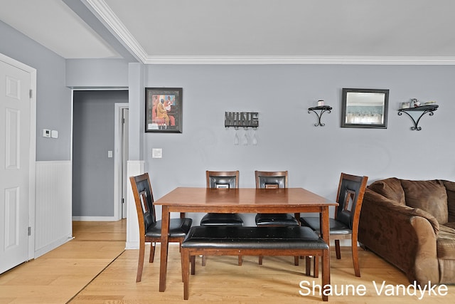 dining room with ornamental molding and light hardwood / wood-style floors