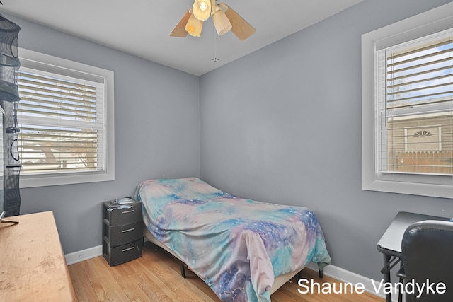 bedroom featuring multiple windows, light hardwood / wood-style floors, and ceiling fan