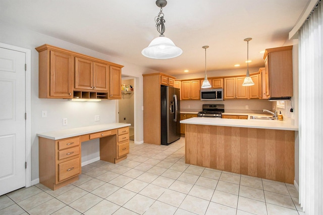 kitchen featuring appliances with stainless steel finishes, built in desk, hanging light fixtures, light tile patterned floors, and kitchen peninsula