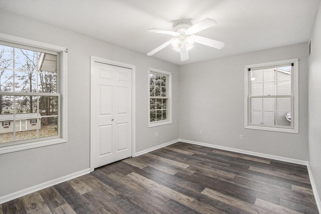 unfurnished bedroom with ceiling fan, dark hardwood / wood-style flooring, and a closet