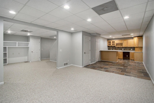 interior space with light brown cabinets, backsplash, and dark carpet