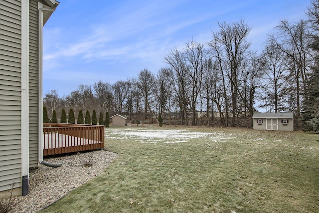 view of yard with a wooden deck and a storage unit