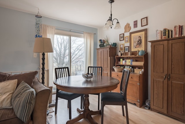 dining area with light hardwood / wood-style floors and a chandelier