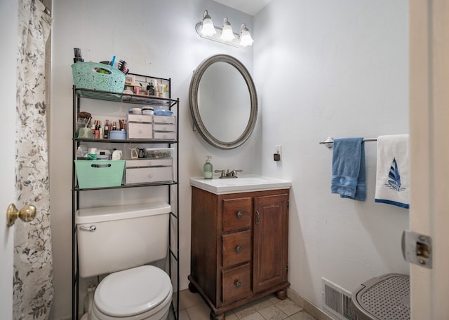 bathroom featuring vanity, toilet, and tile patterned flooring