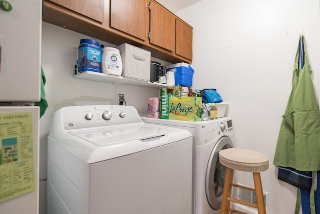 washroom with cabinets and washing machine and clothes dryer