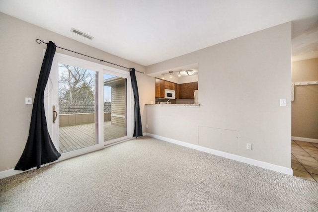 carpeted empty room with track lighting