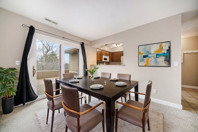 tiled dining space featuring rail lighting