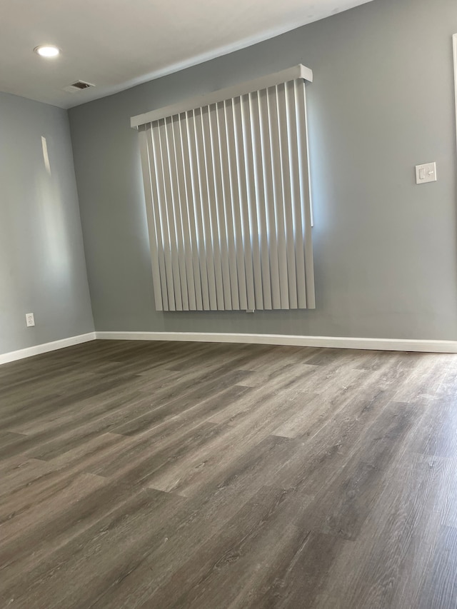 empty room with dark hardwood / wood-style flooring