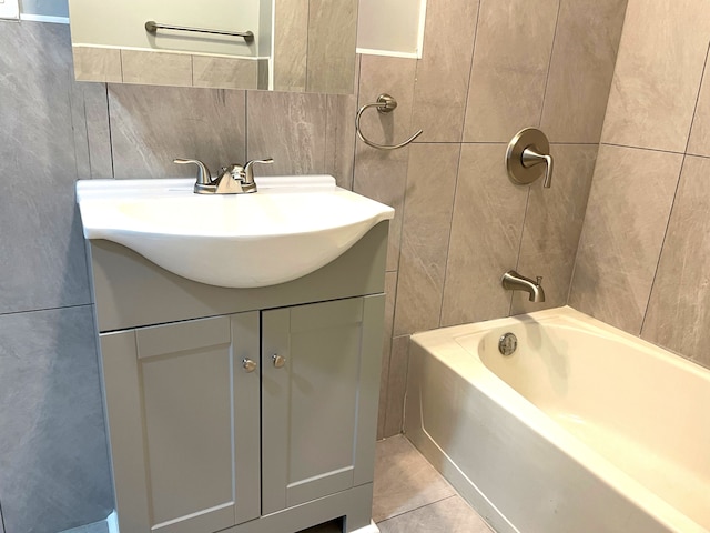 bathroom featuring tile patterned floors, vanity, shower / bath combination, and tile walls