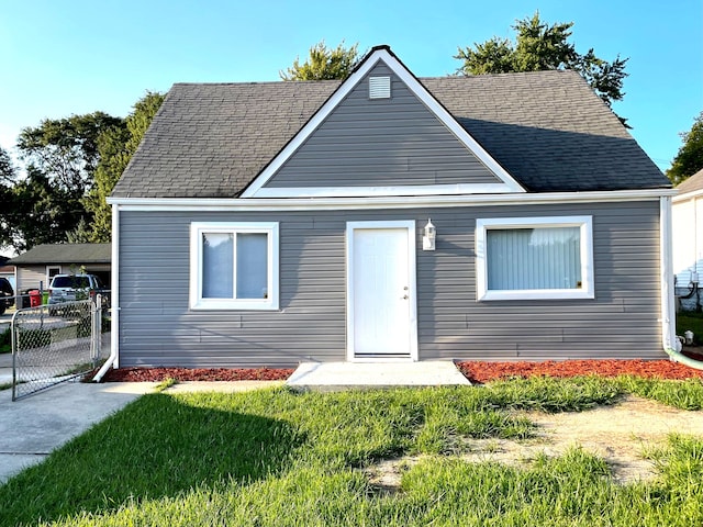 bungalow-style home featuring a front lawn