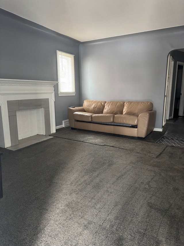 unfurnished living room with dark colored carpet